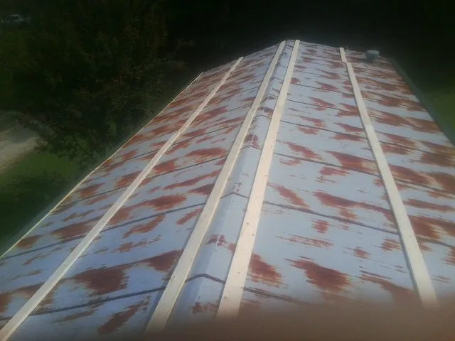 Rusted metal roof panels with new wood purlins before replacement — Storm Damage Roof Repair in Walbridge by Roofing Brothers