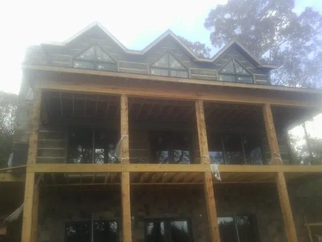 Dormers and porch framing on a large log home under construction — Roof Coating work by our crew in Walbridge