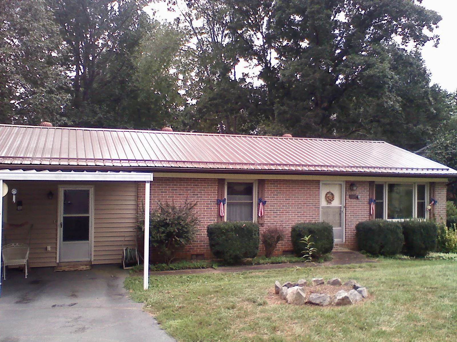 Bronze metal roof and carport on a brick ranch home — Roof Repair work by our crew in Walbridge